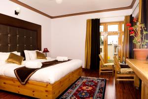 a bedroom with a large bed and a table and chairs at HOTEL NATURE's LAND in Leh