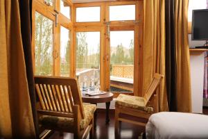a room with a table and chairs and a window at HOTEL NATURE's LAND in Leh