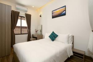 a bedroom with a white bed and a window at Van apartment in Da Nang