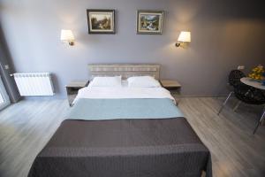 a bedroom with a large bed and a table at Luxury Room in Batumi