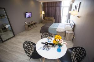 a hotel room with a table and chairs and a bed at Luxury Room in Batumi