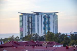 a tall building in the background of a city at Luxury Room in Batumi
