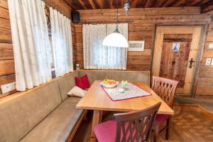 ein Esszimmer in einer Hütte mit einem Tisch und Stühlen in der Unterkunft French Cottage - Franzosenstüberl Chalet in Rennweg