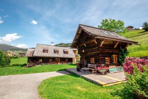 eine Blockhütte mit einer Veranda und einem Haus in der Unterkunft French Cottage - Franzosenstüberl Chalet in Rennweg