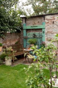 a garden with a bench and a table in a yard at B&B Noordwijk Binnen in Noordwijk