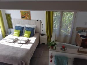 um quarto com uma cama com almofadas verdes e azuis em Chambre d'Hôte - Mas Le Barret em Arles
