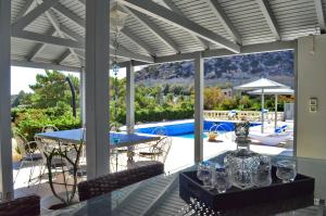 a patio with a table and chairs and a pool at Luxury Villa Melissa in Ferma