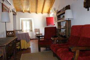 a living room with a red couch and chairs at Estalagem de Marvão in Marvão