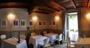 a restaurant with white tables and chairs and a window at Locanda di Orta in Orta San Giulio