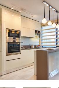 a kitchen with white cabinets and an oven at Apartment Braila in Plovdiv