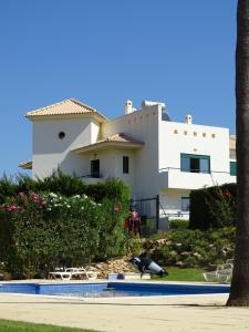 uma casa com um pássaro em frente a uma piscina em Rentalbufeira em Albufeira