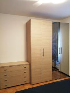 a bedroom with wooden cabinets and a mirror at Casa Carducci in Turate