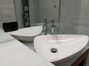 W łazience znajduje się biała umywalka i wanna. w obiekcie Casa Carducci w mieście Turate