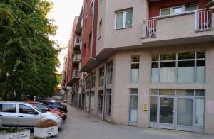 a building with cars parked on the side of a street at Ildo's maisonette in Subotica