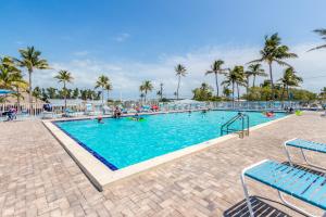 a large swimming pool with palm trees in a resort at Fiesta Key RV Resort Waterfront Cottage 33 in Layton