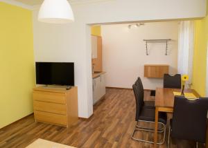 a living room with a dining table and a television at Appartementhaus Thermeneck in Laa an der Thaya