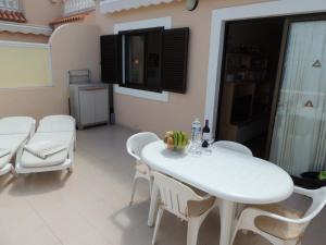 a white dining room with a white table and chairs at Magical Apt. with Sea View & Cliff in Acantilado de los Gigantes