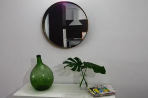 a green vase sitting on a table with a mirror at Apartamento Sauco in Los Llanos de Aridane