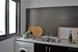 a kitchen with a sink and a washing machine at Apartamento Sauco in Los Llanos de Aridane +16 photos