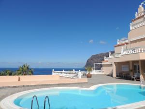 a villa with a swimming pool and a view of the ocean at Luxury Apt. with Stunning Sea View in Acantilado de los Gigantes