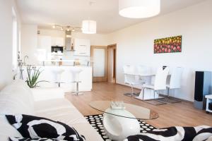 een woonkamer met een witte bank en een tafel bij Prostorný 3 pokojový apartmán s dvěma terasami in Praag