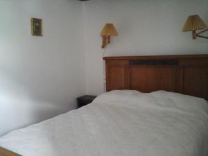 1 dormitorio con 1 cama blanca y 2 lámparas en la pared en les Millefonds, en Valdeblore