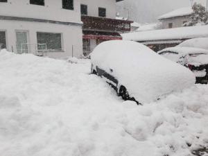 un'auto coperta da neve è coperta di neve di Casa di vivian in montagna con giardino Alpe di siusi Fie allo sciliar Bolzano a Fié allo Sciliar