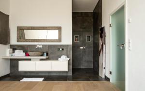 łazienka z białą umywalką i lustrem w obiekcie Ferienappartement Vastu w mieście Pflach