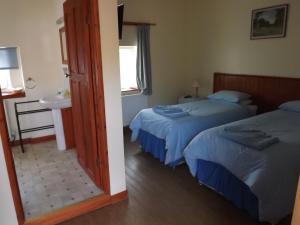 1 dormitorio con 2 camas, lavabo y espejo en Peartree Farm, en Aldwincle Saint Peter