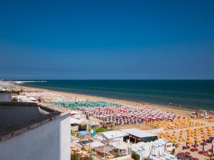 een uitzicht op een strand met parasols en de oceaan bij Hotel Villa Sorriso in Senigallia