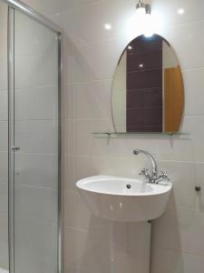 a bathroom with a sink and a mirror at Mladost Apartments Sofia in Sofia