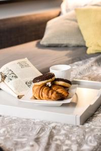 um prato de pastelaria e uma chávena de café numa cama em Katowice City Centre Apartment em Katowice