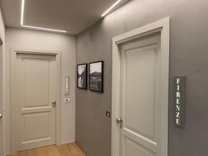 un corridoio con due porte e due foto sul muro di Palazzo Vasarri - Luxury design suites a Montevarchi