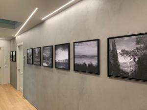 un grupo de fotografías enmarcadas en una pared en Palazzo Vasarri - Luxury design suites en Montevarchi