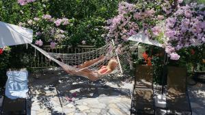 a woman laying in a hammock in a garden at Filoxenia Sea View in Parga