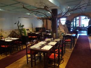 ein Esszimmer mit Tischen, Stühlen und einem Baum in der Unterkunft Desperados Hotel in Bergen