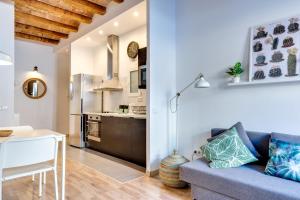 バルセロナにあるCharming & Convenient Apartment Near Plaza Espanyaのリビングルーム(ソファ、テーブル付)、キッチンが備わります。