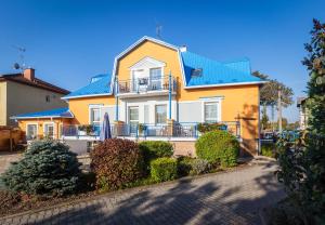 une maison jaune et blanche avec un toit bleu dans l'établissement Penzion Sirius, à Vyškov