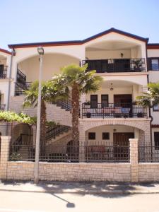 a building with palm trees in front of it at Apartments Modrušan in Rovinj