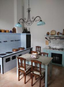 una cucina con tavolo, sedie e piano cottura di Palazzo Pio Apartment a Lecce