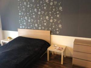 Un dormitorio con una pared en blanco y negro con una cama y una mesa en Velence Wellness Apartman, en Velence