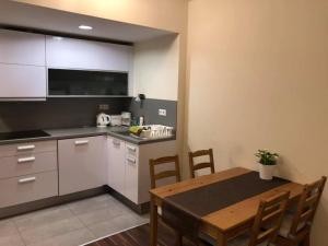 a kitchen with a table and a dining room at Velence Wellness Apartman in Velence