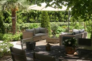 a patio with a table and chairs and an umbrella at Chambre d'Hôtes La Villa Molina in Besançon