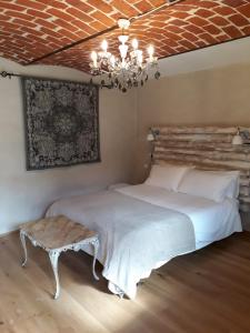 a bedroom with a white bed and a chandelier at La Mela Antica in Cherasco
