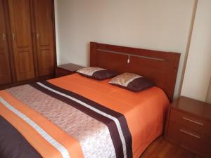 a bedroom with a bed with two pillows on it at Apartamento Arosa in Santa Maria Da Feira