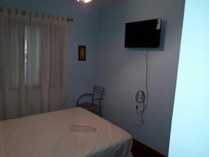 1 dormitorio con 1 cama y TV de pantalla plana en Departamento en Ciudad Mendoza en Mendoza