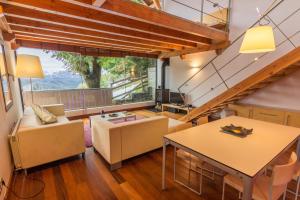 a living room with a table and chairs and a large window at Borda Aranzazu in Oñati