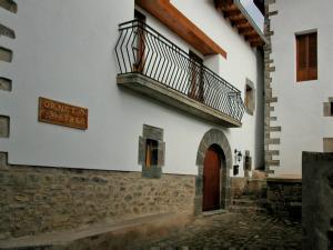 a white building with a balcony and a door at Casa rural Ornat Etxea in Vidángoz