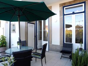 patio con tavolo, sedie e ombrellone di Cool Terrace Apartment a Porto