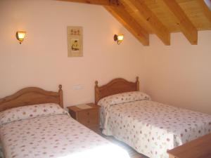 a bedroom with two beds and two lights at Casa rural Ornat Etxea in Vidángoz